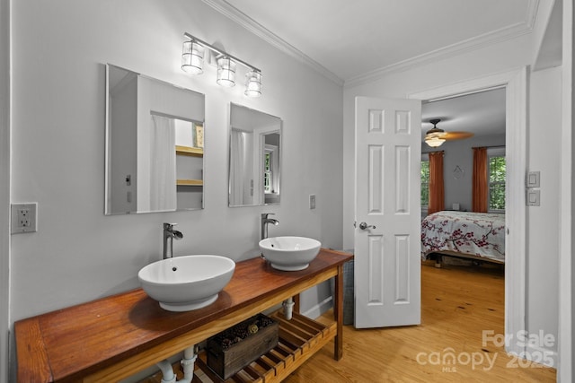 bathroom with crown molding, wood finished floors, ensuite bathroom, and double vanity