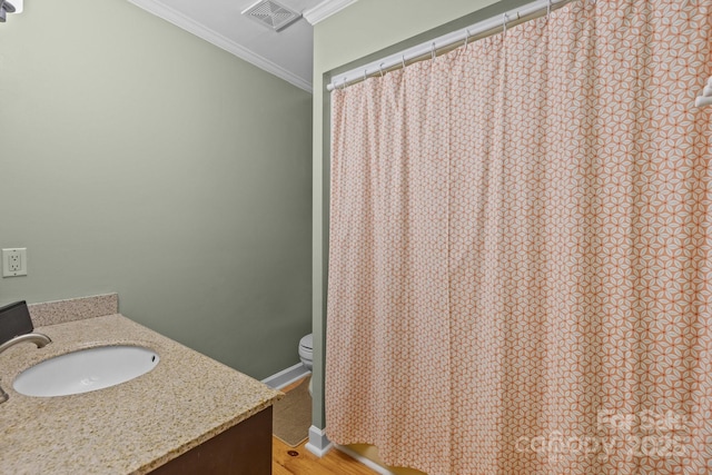 full bathroom featuring crown molding, toilet, vanity, wood finished floors, and baseboards