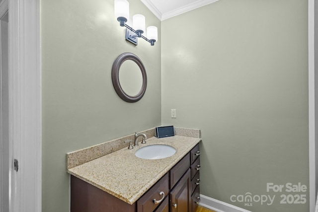 bathroom featuring ornamental molding, vanity, and baseboards