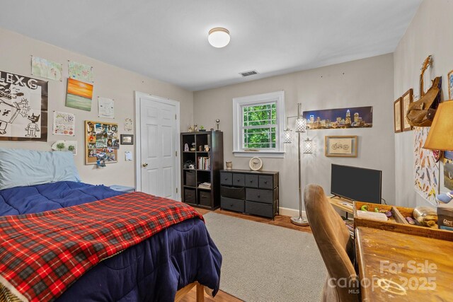 bedroom featuring wood finished floors and baseboards