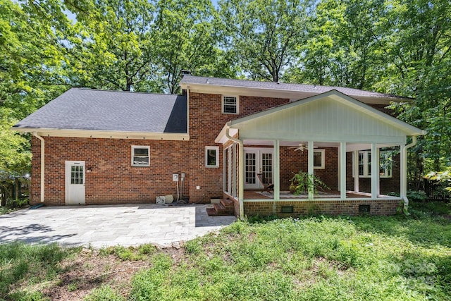 rear view of property with french doors, a patio area, brick siding, and roof with shingles
