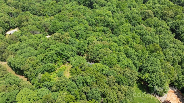 aerial view of property and surrounding area with a heavily wooded area