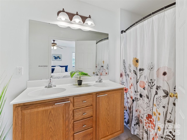 ensuite bathroom with double vanity, a sink, ceiling fan, and connected bathroom