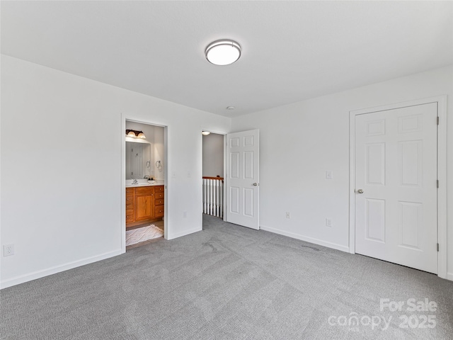 unfurnished bedroom featuring ensuite bath, carpet, and baseboards