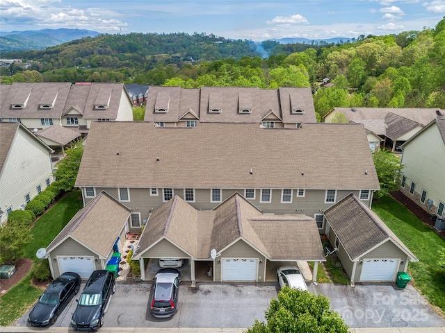 birds eye view of property featuring a residential view, a mountain view, and a forest view
