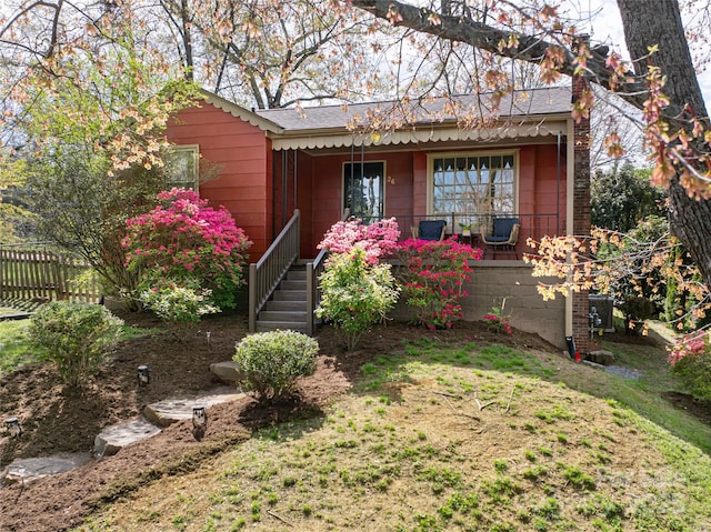 view of front of home with covered porch and fence