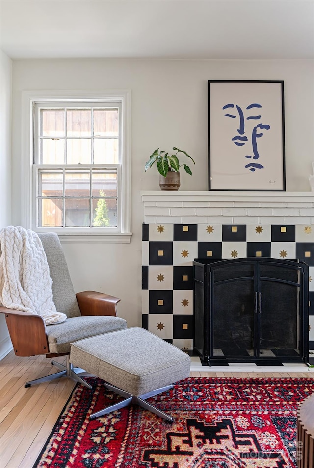 sitting room with light wood-type flooring and a fireplace