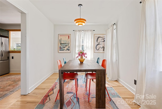 dining room featuring baseboards and light wood-type flooring