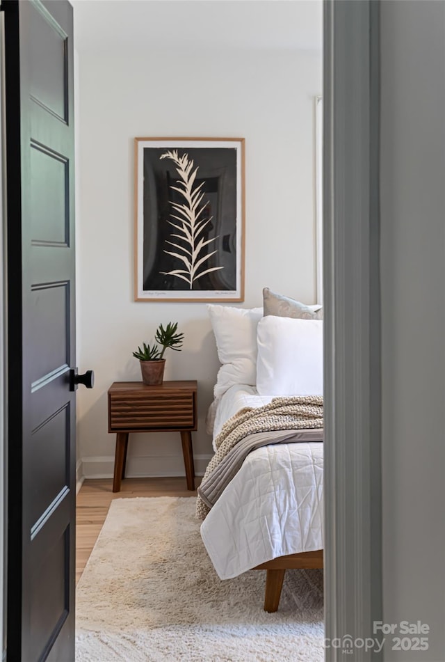 bedroom with light wood-style flooring and baseboards