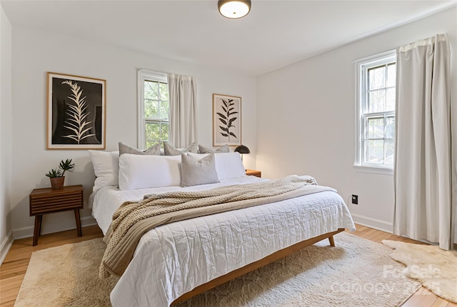 bedroom featuring baseboards and light wood-style flooring