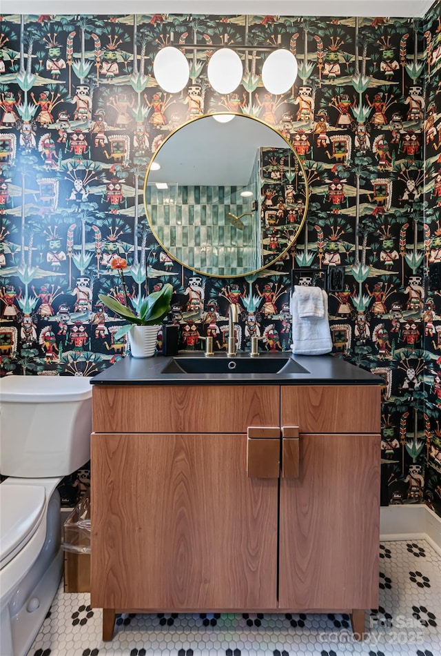 half bathroom with toilet, tile patterned flooring, and vanity