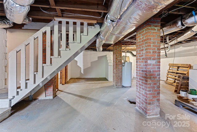 unfinished below grade area featuring gas water heater and stairs