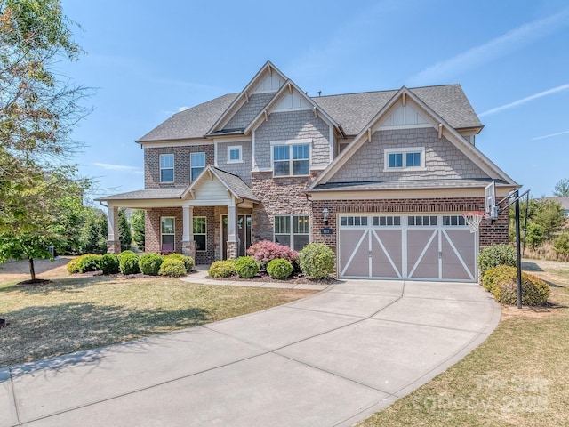 craftsman inspired home featuring a front lawn, driveway, stone siding, a porch, and a shingled roof