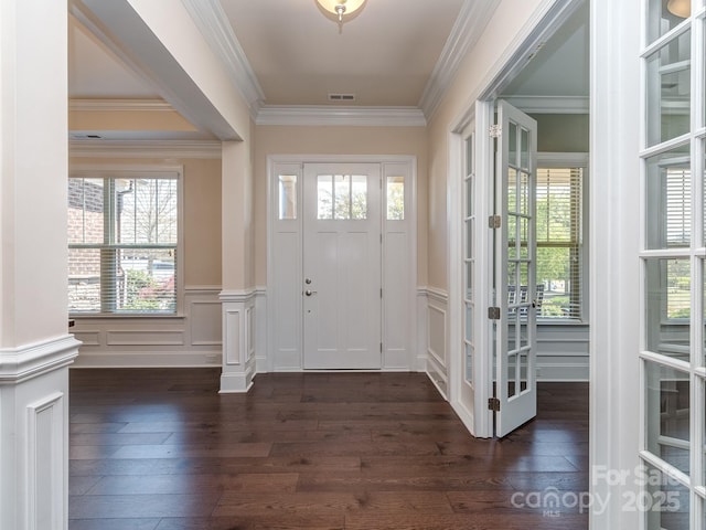 entryway with crown molding, a wainscoted wall, dark wood-type flooring, and a decorative wall