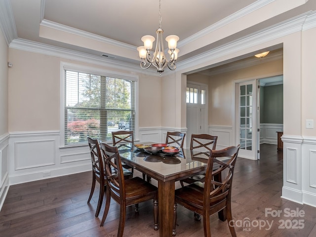 dining area featuring wainscoting, an inviting chandelier, dark wood finished floors, and a healthy amount of sunlight