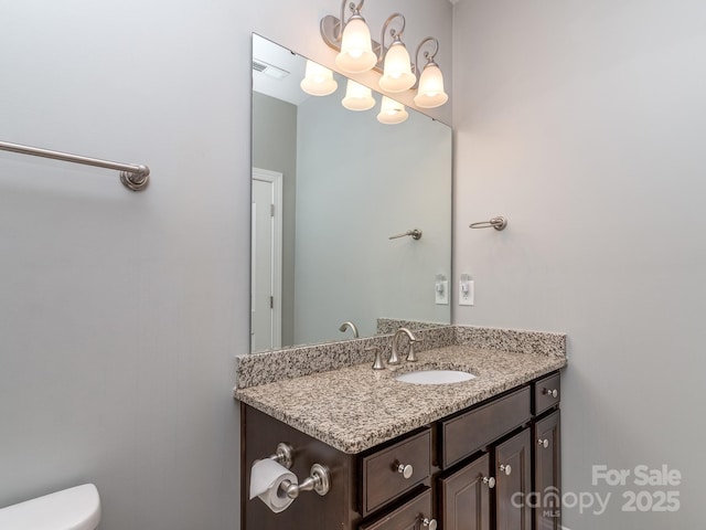 bathroom featuring visible vents, toilet, and vanity