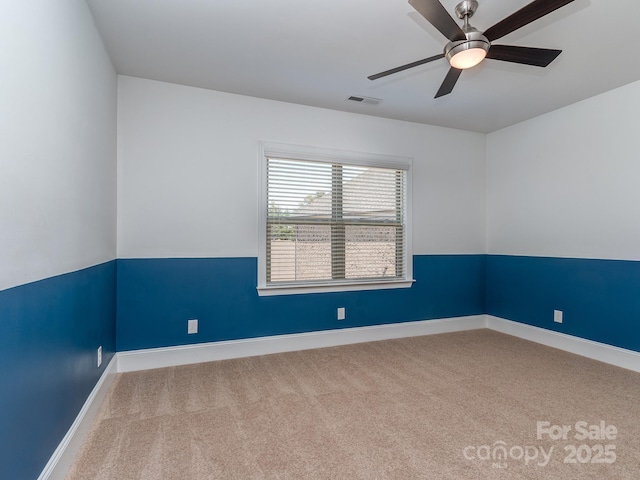 spare room featuring ceiling fan, baseboards, visible vents, and carpet