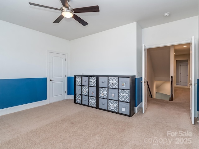 carpeted empty room featuring ceiling fan