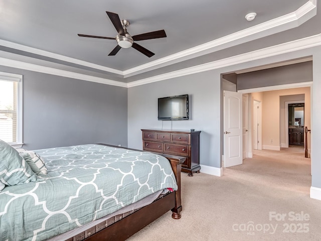 bedroom with a tray ceiling, baseboards, light colored carpet, a ceiling fan, and ornamental molding