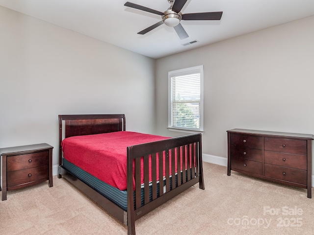 carpeted bedroom featuring baseboards, a ceiling fan, and visible vents