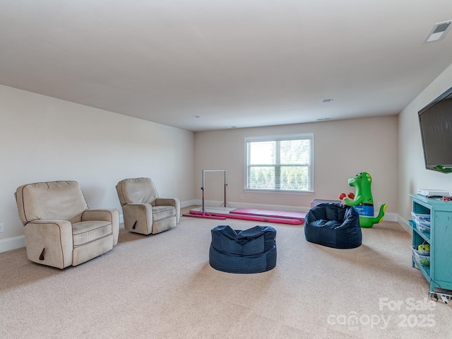 living area featuring baseboards, visible vents, and carpet