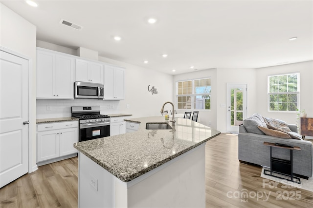 7004 Everly Commons Ln, Tega Cay, SC 29708 - kitchen featuring stainless steel appliances, visible vents, a sink, a center island with sink, and light wood-style flooring