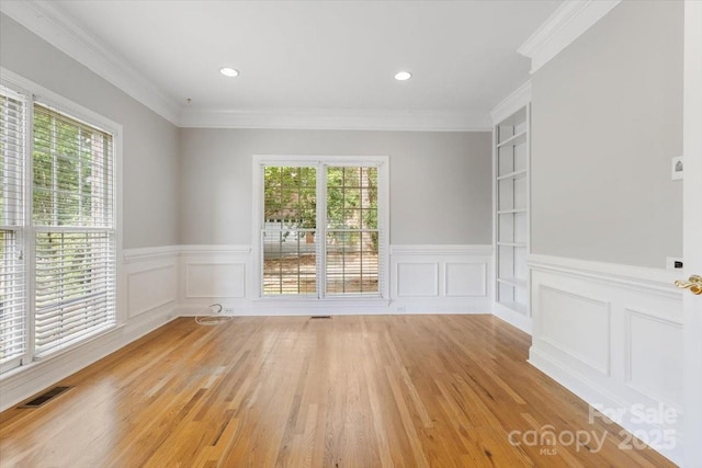 empty room with light wood-style flooring, visible vents, and plenty of natural light