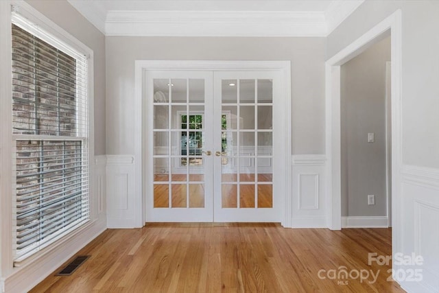 doorway to outside with crown molding, french doors, wood finished floors, and visible vents