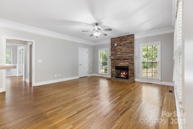 unfurnished living room featuring a ceiling fan, a fireplace, light wood-style floors, and ornamental molding