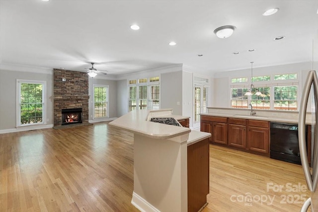 kitchen featuring crown molding, brown cabinets, dishwasher, ceiling fan, and light countertops