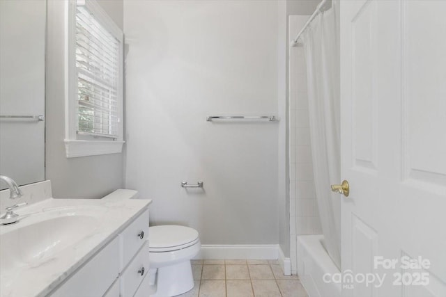 full bath with tile patterned floors, toilet, vanity, baseboards, and shower / bath combo