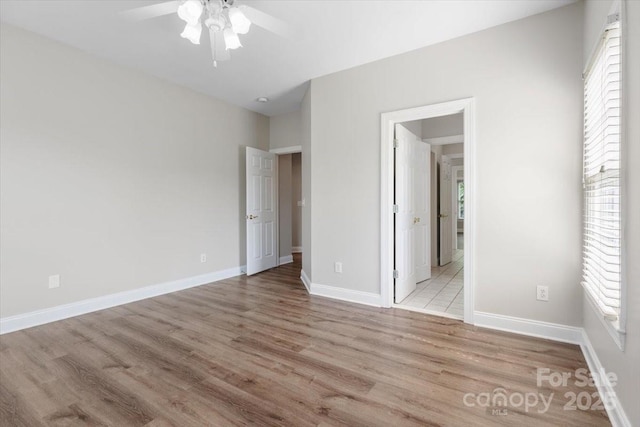 unfurnished bedroom featuring ceiling fan, baseboards, and wood finished floors
