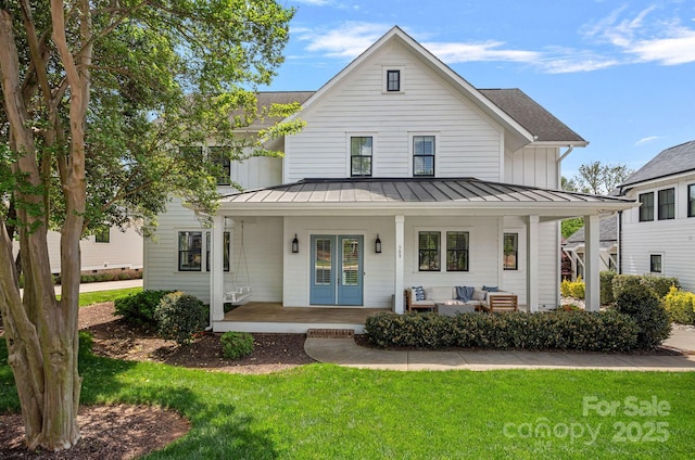 309 Catawba Ave, Davidson, NC 28036 - modern farmhouse featuring a standing seam roof, a front yard, a porch, and an outdoor hangout area