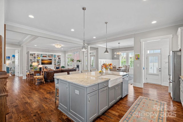 309 Catawba Ave, Davidson, NC 28036 - kitchen with gray cabinets, appliances with stainless steel finishes, open floor plan, a center island, and a sink