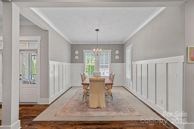 309 Catawba Ave, Davidson, NC 28036 - dining space featuring a chandelier, wood finished floors, a decorative wall, a wainscoted wall, and crown molding