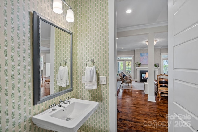 309 Catawba Ave, Davidson, NC 28036 - bathroom with wallpapered walls, ornamental molding, wood finished floors, a sink, and baseboards