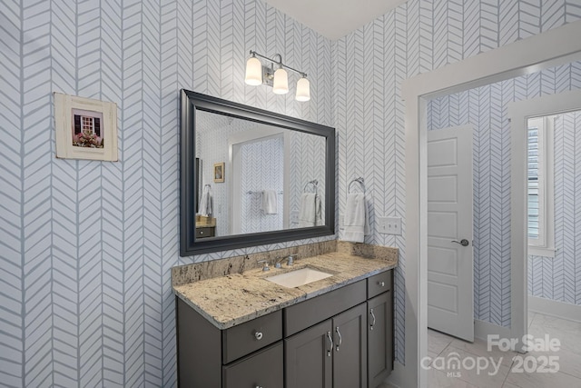 309 Catawba Ave, Davidson, NC 28036 - bathroom featuring vanity, wallpapered walls, marble look tile flooring, and baseboards