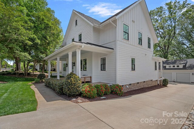 309 Catawba Ave, Davidson, NC 28036 - view of front facade with board and batten siding, covered porch, driveway, crawl space, and a front yard