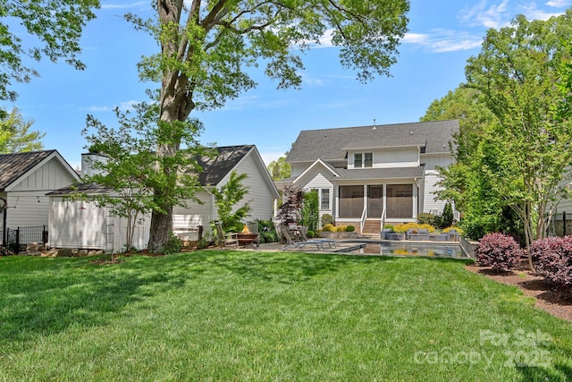 309 Catawba Ave, Davidson, NC 28036 - back of property featuring a sunroom, a patio, a yard, and an outdoor structure