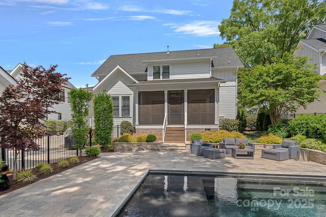 309 Catawba Ave, Davidson, NC 28036 - rear view of property featuring a sunroom, a patio, outdoor lounge area, and roof with shingles