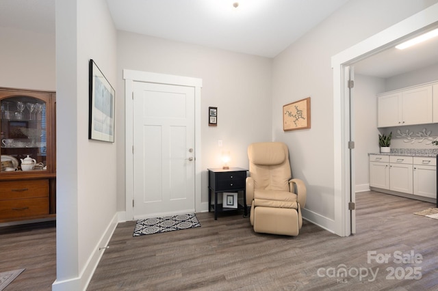living area featuring wood finished floors and baseboards