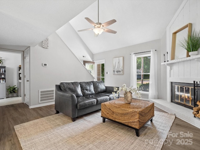 living room featuring a healthy amount of sunlight, a ceiling fan, wood finished floors, and visible vents