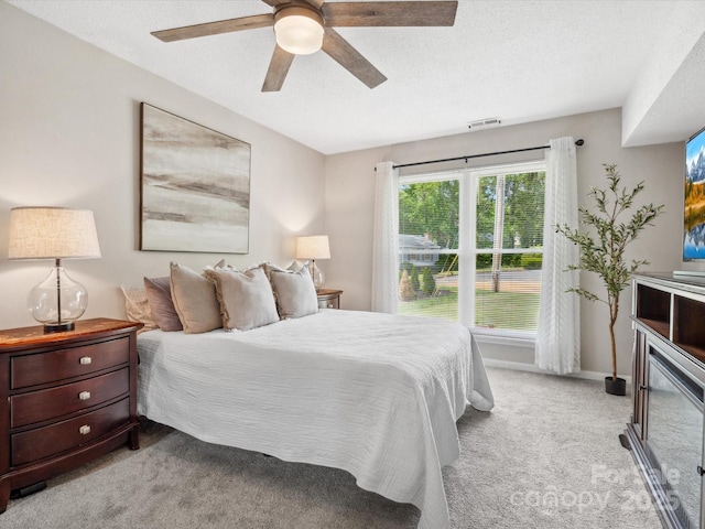 bedroom with light colored carpet, a ceiling fan, baseboards, and visible vents
