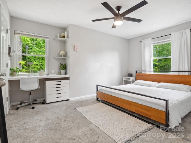 carpeted bedroom featuring baseboards and a ceiling fan
