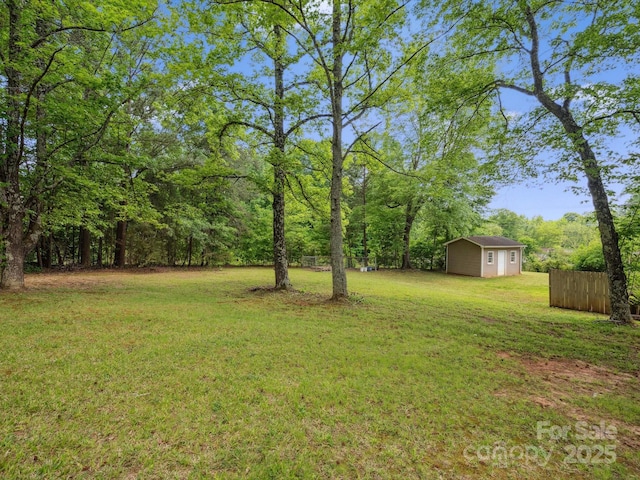 view of yard featuring an outdoor structure and fence