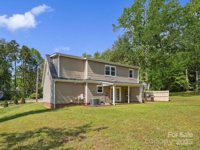 rear view of house with a lawn, cooling unit, and a porch