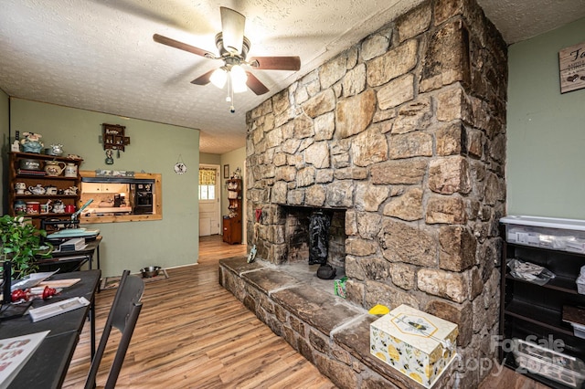 1300 Math Pl, Lenoir, NC 28645 - living area featuring ceiling fan, a fireplace, a textured ceiling, and wood finished floors