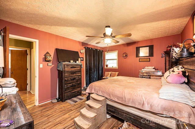 1300 Math Pl, Lenoir, NC 28645 - bedroom with baseboards, a textured ceiling, ceiling fan, and wood finished floors