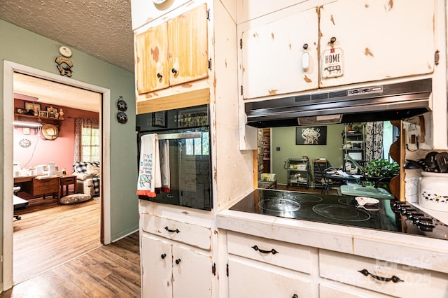 1300 Math Pl, Lenoir, NC 28645 - kitchen featuring wood finished floors, light countertops, white cabinetry, under cabinet range hood, and black appliances