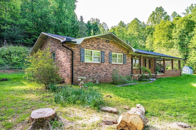 1300 Math Pl, Lenoir, NC 28645 - view of front of home with a storage unit, brick siding, a porch, a front yard, and an outbuilding
